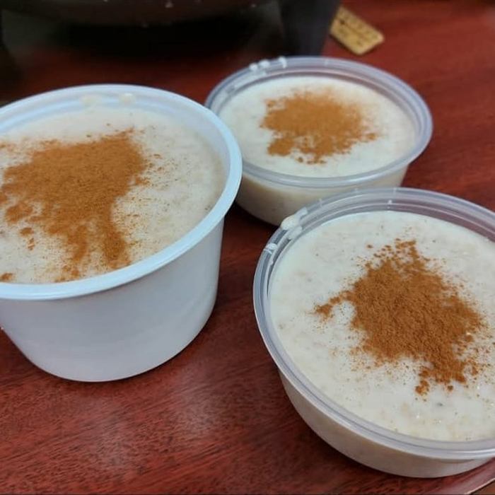 Tres envases con cremas de harina de maíz, avena y maicena espolvoreadas con canela sobre una mesa de madera